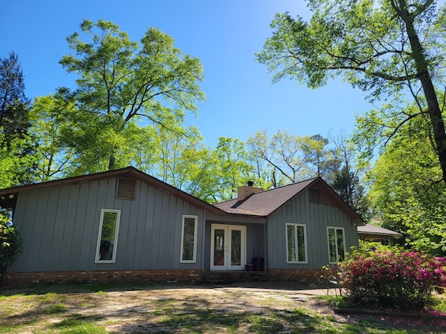 7505 Beaver Run Rd, Midland, GA 31820 - view of front facade with french doors, a chimney, and board and batten siding