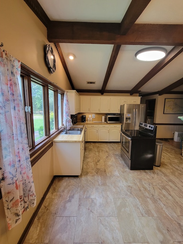 7505 Beaver Run Rd, Midland, GA 31820 - kitchen with stainless steel appliances, beam ceiling, white cabinetry, and light countertops