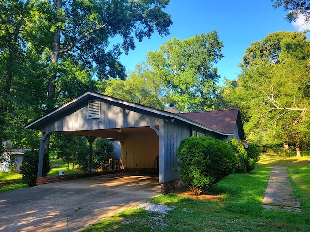 7505 Beaver Run Rd, Midland, GA 31820 - view of side of home with a chimney, driveway, roof with shingles, a carport, and a lawn