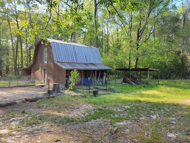 7505 Beaver Run Rd, Midland, GA 31820 - exterior space featuring a gambrel roof, a barn, a metal roof, an outdoor structure, and a forest view