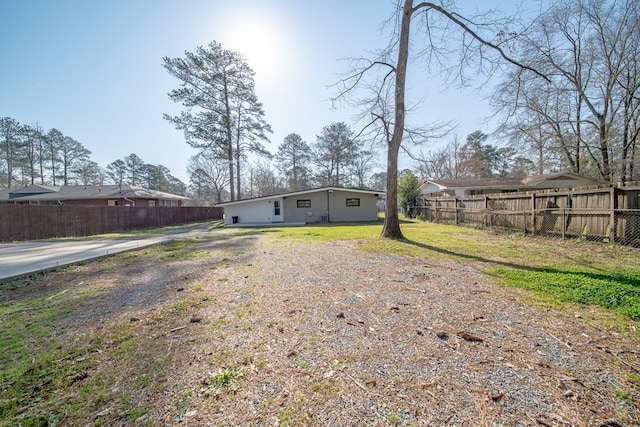 view of yard with fence and driveway