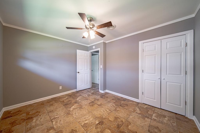 unfurnished bedroom with ornamental molding, a ceiling fan, stone finish flooring, a closet, and baseboards