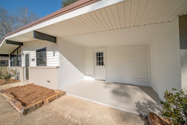 doorway to property featuring brick siding