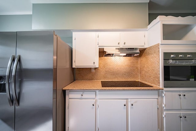 kitchen featuring under cabinet range hood, stainless steel appliances, white cabinets, and decorative backsplash