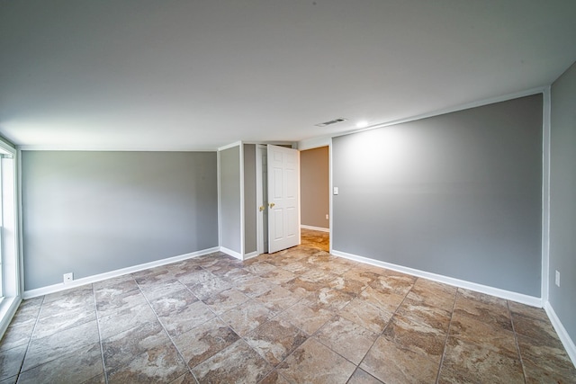 spare room with visible vents, stone finish floor, and baseboards