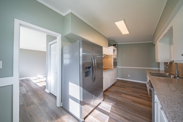 kitchen featuring dark wood finished floors, tasteful backsplash, appliances with stainless steel finishes, and a sink