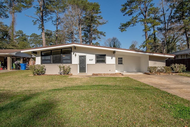 mid-century home featuring an attached carport, a front yard, and driveway