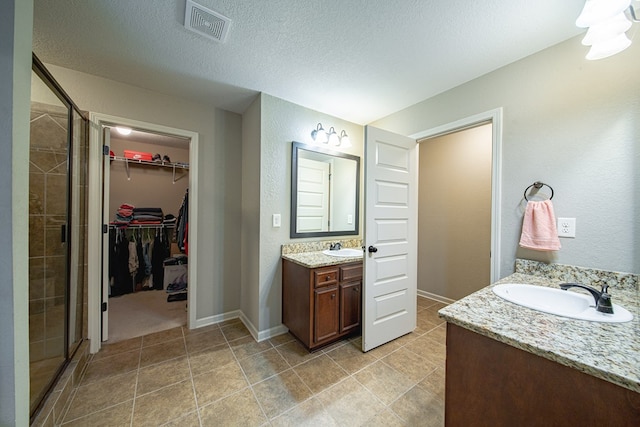 9742 Wooldridge Heights Dr, Fortson, GA 31808 - bathroom with a shower stall, visible vents, two vanities, and a sink