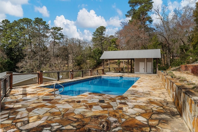 view of pool featuring a fenced in pool, a patio, and an outdoor structure