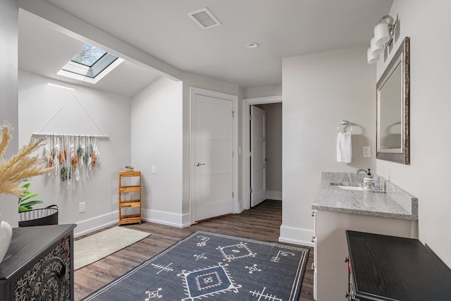 interior space featuring visible vents, baseboards, and wood finished floors