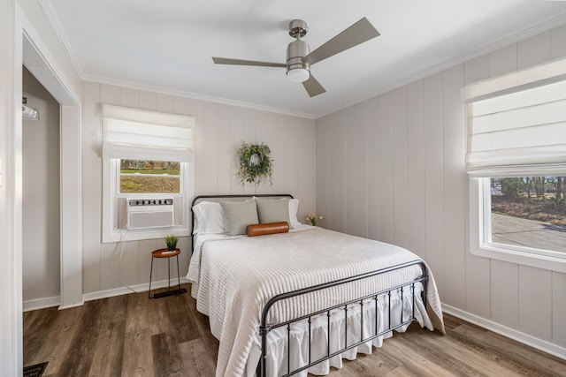 bedroom featuring multiple windows, wood finished floors, and ornamental molding