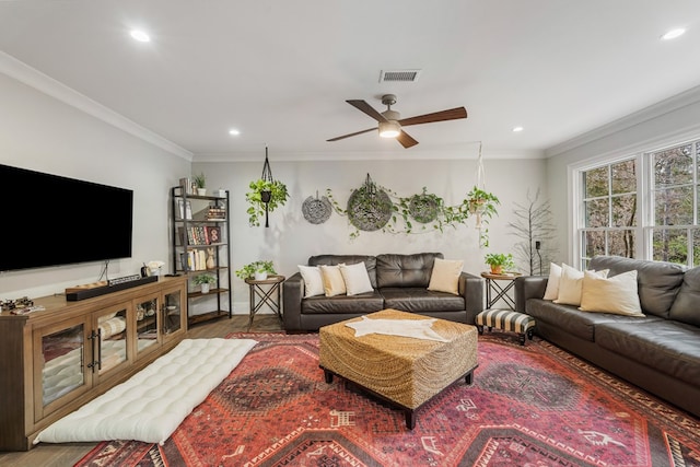 living room featuring visible vents, baseboards, ornamental molding, recessed lighting, and wood finished floors