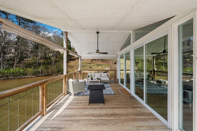 wooden deck with an outdoor living space and a ceiling fan