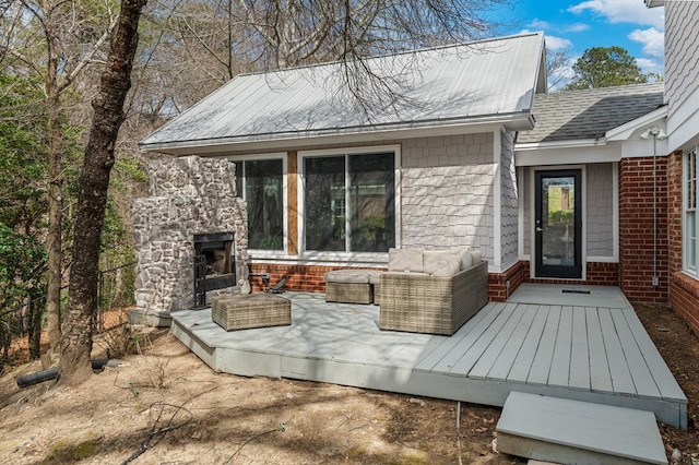 exterior space with an outdoor living space with a fireplace, brick siding, and roof with shingles