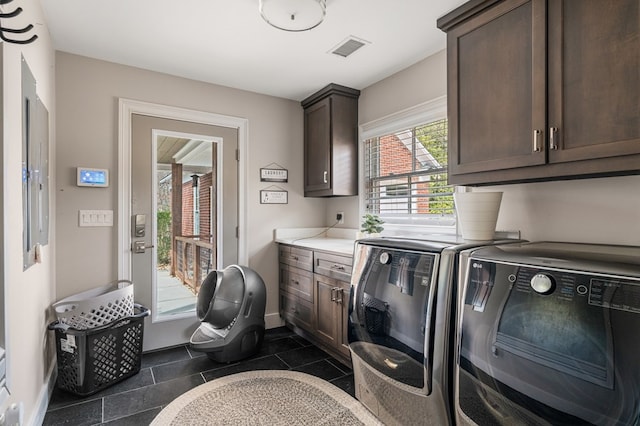 laundry room featuring baseboards, cabinet space, visible vents, and washing machine and clothes dryer