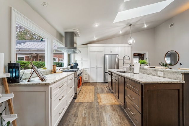 kitchen featuring visible vents, a sink, appliances with stainless steel finishes, white cabinets, and island range hood