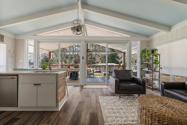 living area featuring lofted ceiling with beams, a chandelier, dark wood-style flooring, and a sunroom