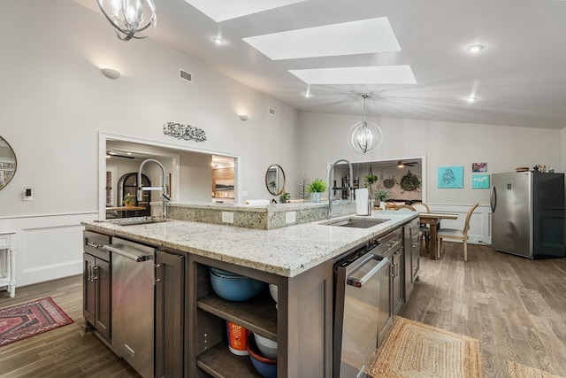 kitchen with a sink, a notable chandelier, visible vents, and stainless steel appliances