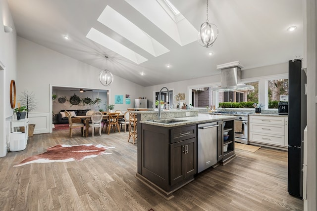 kitchen featuring light wood-type flooring, a sink, appliances with stainless steel finishes, island range hood, and a chandelier