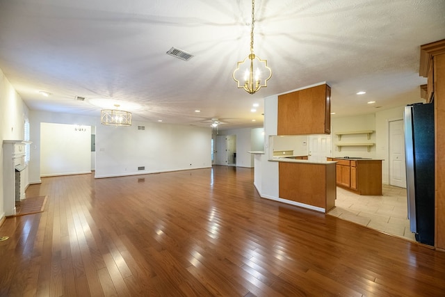 1820 Overlook St, Columbus, GA 31906 - kitchen with a chandelier, brown cabinets, open floor plan, freestanding refrigerator, and a ceiling fan