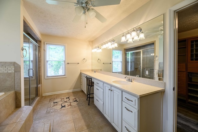 1820 Overlook St, Columbus, GA 31906 - full bathroom with double vanity, a textured ceiling, ceiling fan, a stall shower, and a garden tub