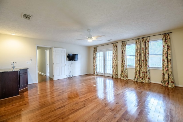 1820 Overlook St, Columbus, GA 31906 - unfurnished living room featuring a textured ceiling, a ceiling fan, and light wood-style floors