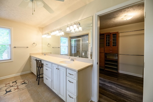 1820 Overlook St, Columbus, GA 31906 - full bath with a textured ceiling, double vanity, a shower stall, ceiling fan, and tile patterned floors