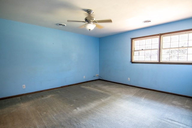 spare room with dark carpet and ceiling fan