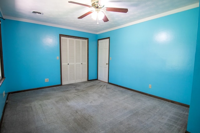 unfurnished bedroom featuring carpet flooring, ceiling fan, and ornamental molding