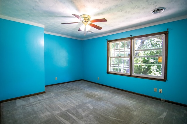 carpeted spare room featuring a textured ceiling, ceiling fan, and crown molding