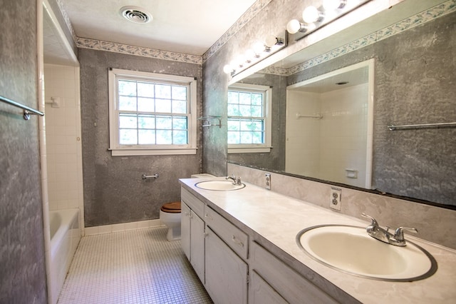 full bathroom with tile patterned floors, a wealth of natural light, vanity, and toilet