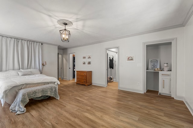 7172 Standing Boy Rd, Columbus, GA 31904 - bedroom with light wood-style flooring, ornamental molding, and a walk in closet