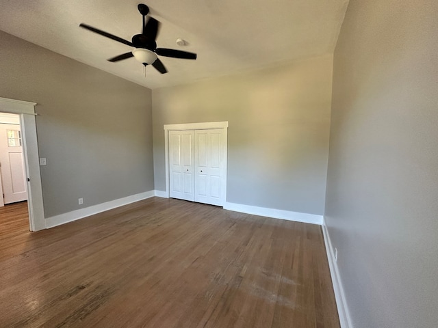 unfurnished bedroom featuring ceiling fan, a closet, lofted ceiling, and hardwood / wood-style flooring