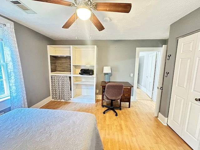 bedroom with light wood-type flooring, a closet, and ceiling fan