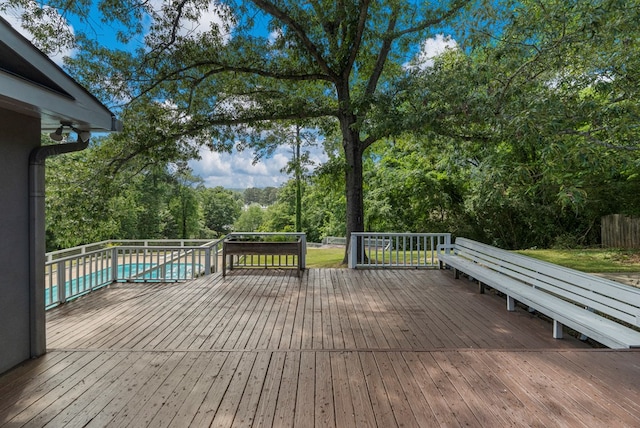 wooden deck with a fenced in pool