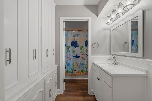 bathroom featuring a shower with curtain, vanity, wainscoting, and wood finished floors