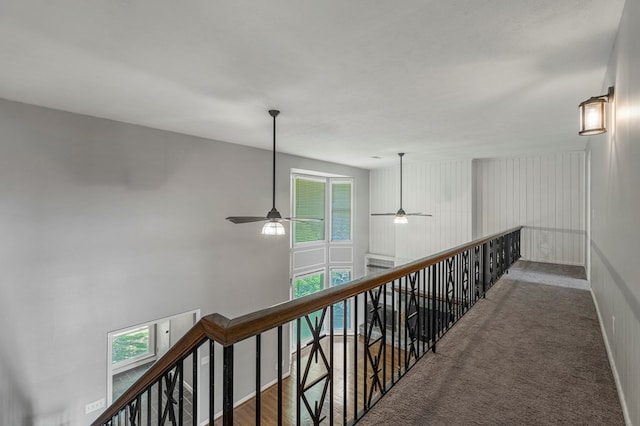corridor featuring carpet flooring and an upstairs landing