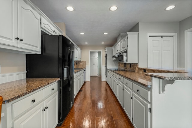 kitchen with recessed lighting, dark wood-style floors, a sink, and black appliances