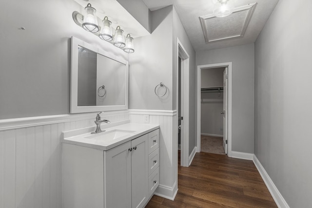 bathroom with vanity, wainscoting, and wood finished floors