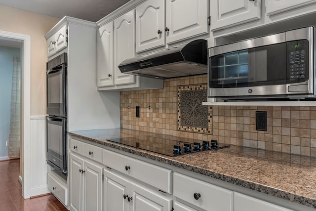 kitchen featuring white cabinetry, under cabinet range hood, and black appliances