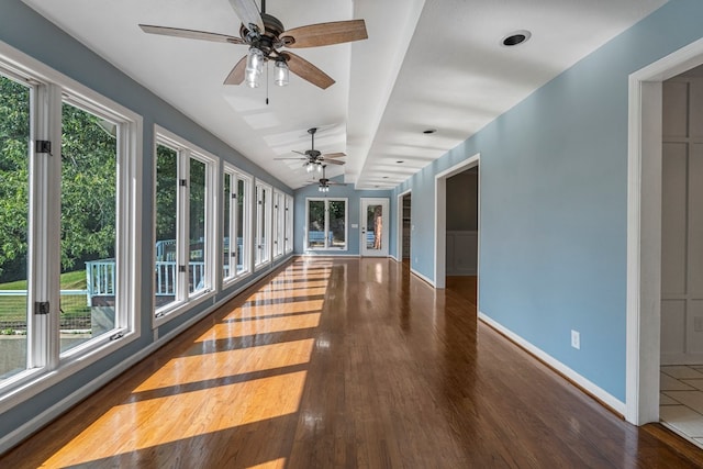 interior space with baseboards, wood finished floors, and a wealth of natural light