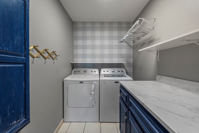 laundry room featuring washer and dryer, light tile patterned floors, and cabinet space