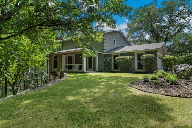 back of property with covered porch, stucco siding, and a yard