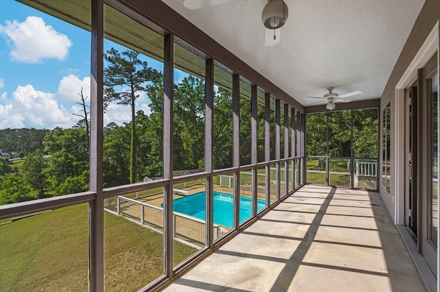 unfurnished sunroom with ceiling fan