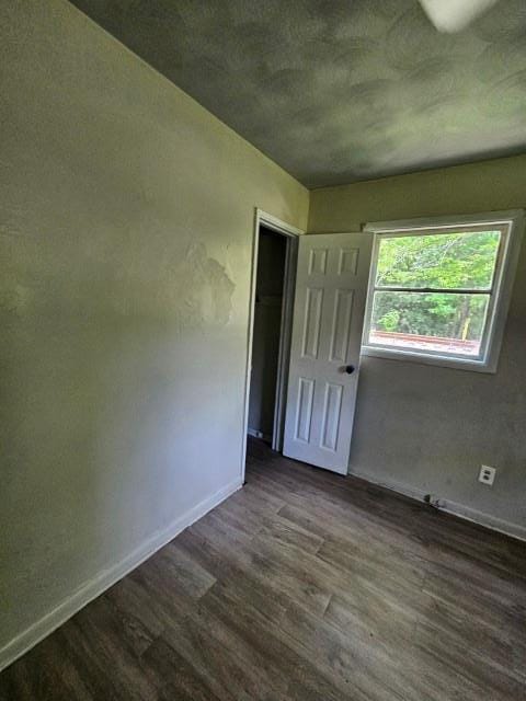 unfurnished bedroom with dark hardwood / wood-style flooring