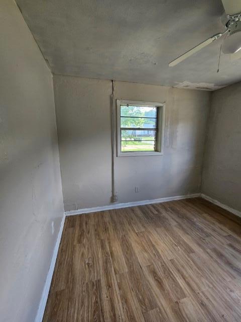 empty room with hardwood / wood-style flooring and ceiling fan