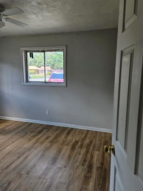 empty room with a textured ceiling and hardwood / wood-style flooring