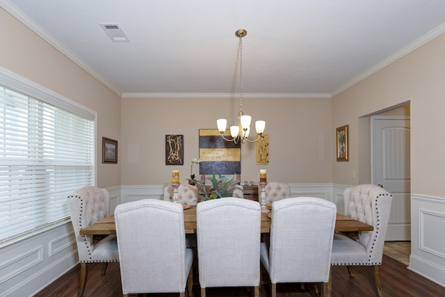 dining space featuring an inviting chandelier, visible vents, wood finished floors, and wainscoting