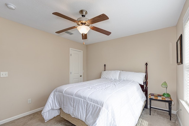 bedroom with a ceiling fan, light colored carpet, visible vents, and baseboards