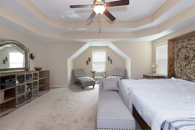 bedroom with carpet floors, a tray ceiling, baseboards, and a ceiling fan